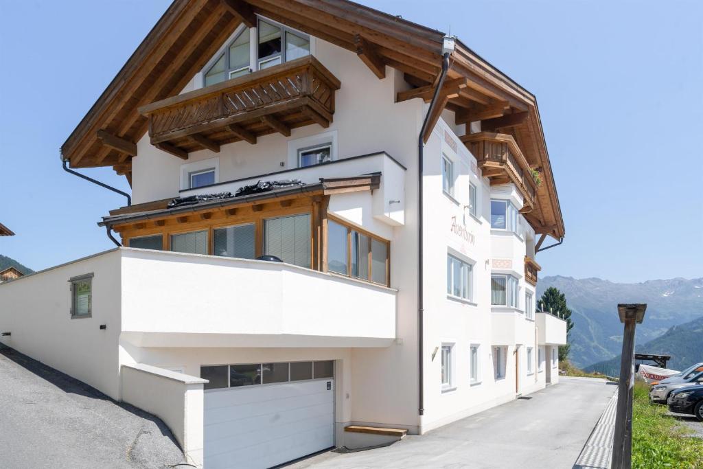 a white building with a wooden roof at Haus Aventurin in Fiss