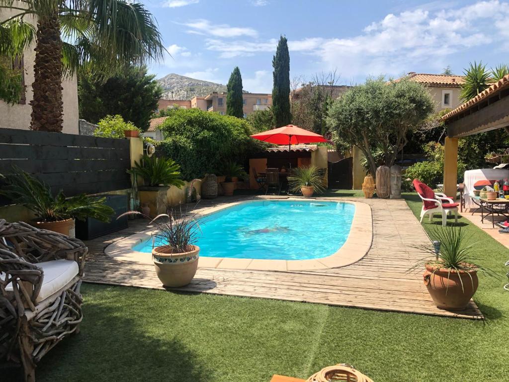 - une piscine dans une cour avec une terrasse en bois dans l'établissement chez Guy, à Marseille
