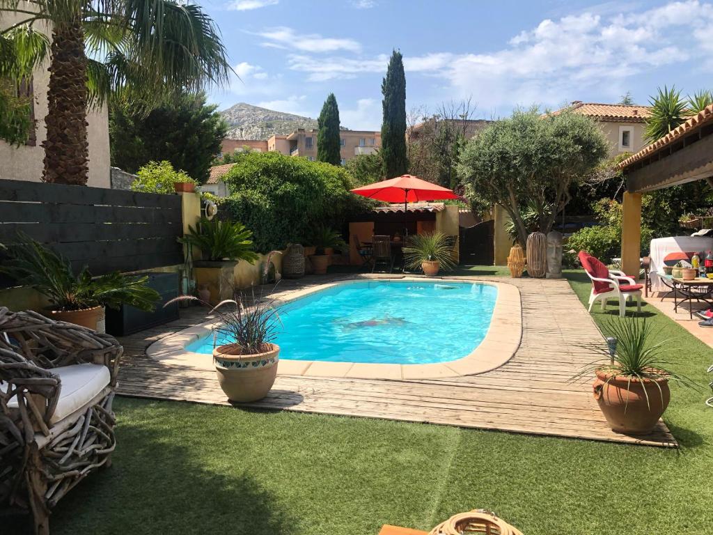 a swimming pool in a yard with a wooden deck at chez Guy in Marseille