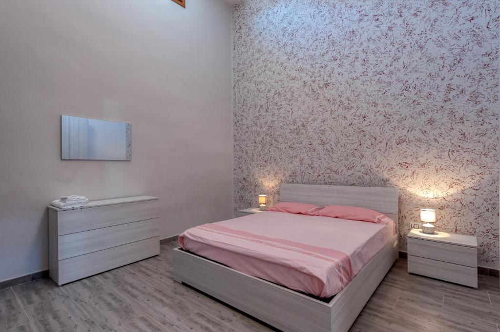 a bedroom with a bed and two night stands and a tv at Casa vacanze Petra in Squinzano