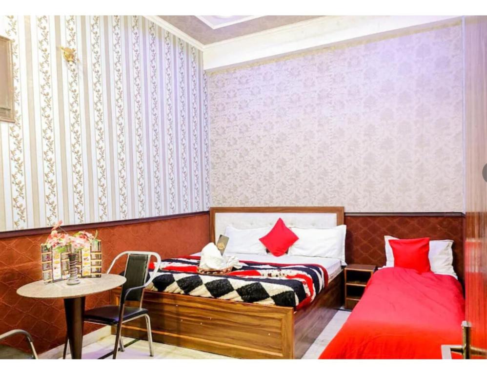 a bedroom with two beds and a table and a table at Osaka Taj Hotel, Agra in Agra