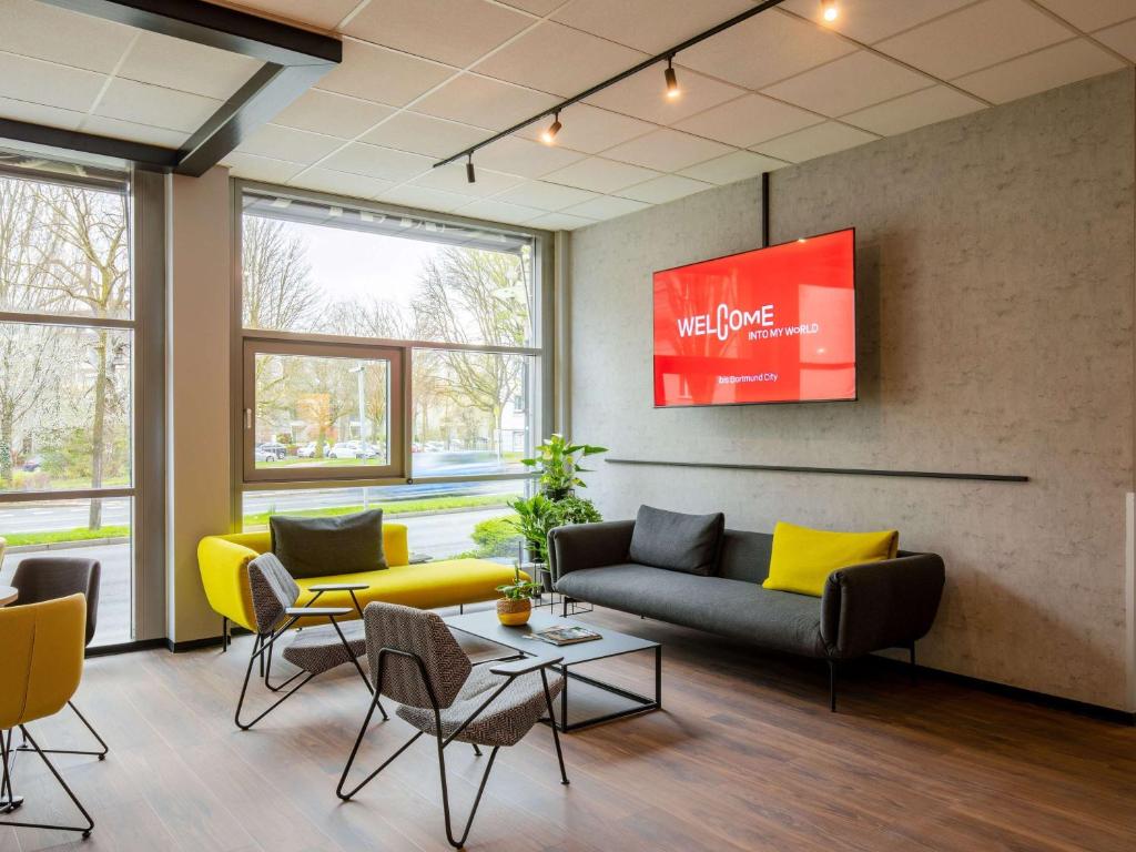 a waiting room with a couch and chairs at ibis Hotel Dortmund City in Dortmund