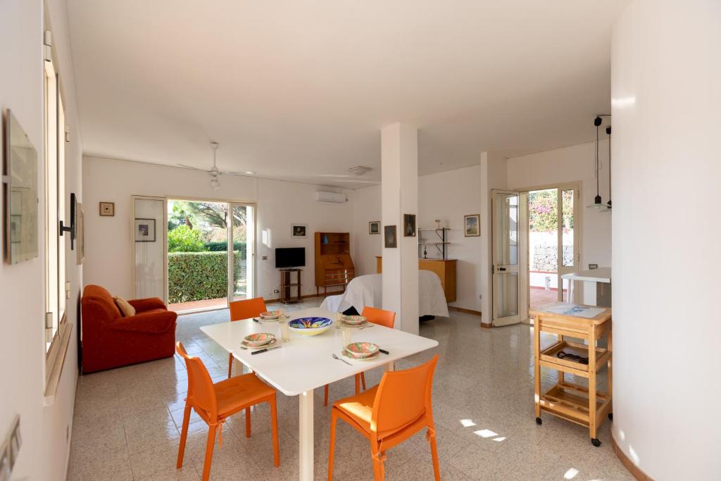 a living room with a white table and chairs at L'isola di Gianni by Ortigia Apartments in Plemmirio