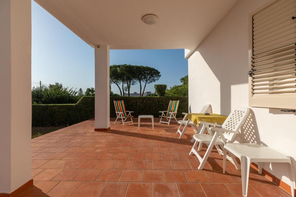 a patio with chairs and a table on a patio at L'isola di Gianni by Ortigia Apartments in Plemmirio