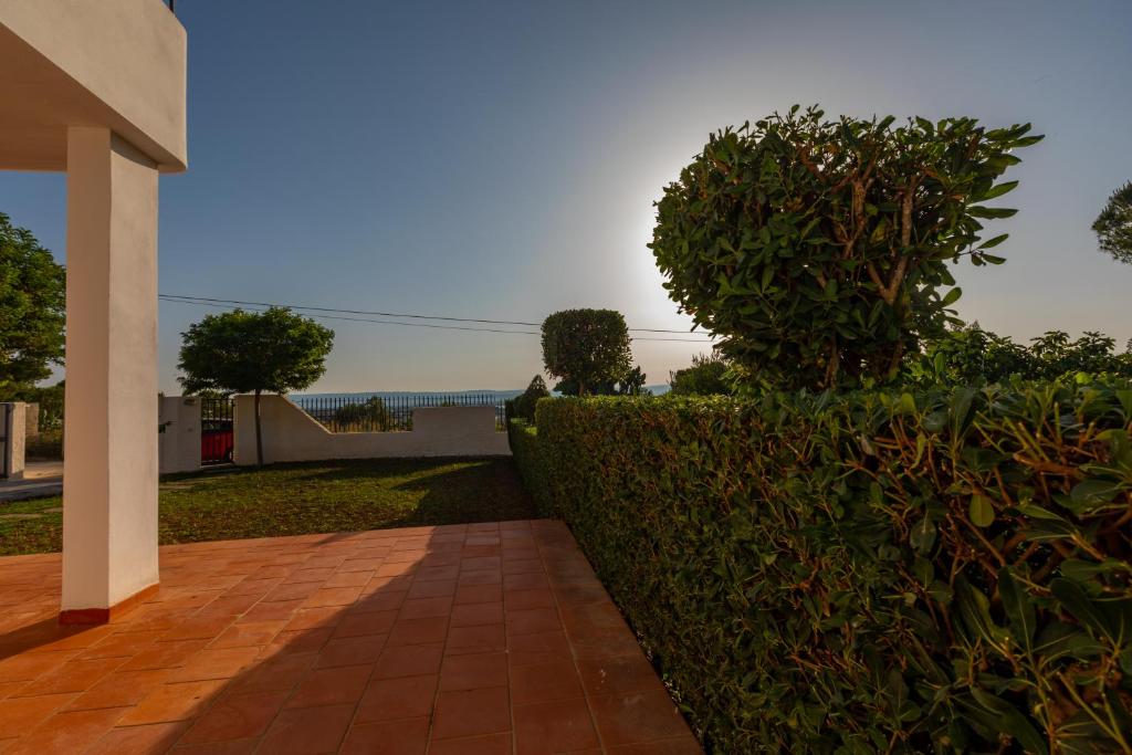 a hedge in front of a house with a walkway at L'isola di Gianni by Ortigia Apartments in Plemmirio