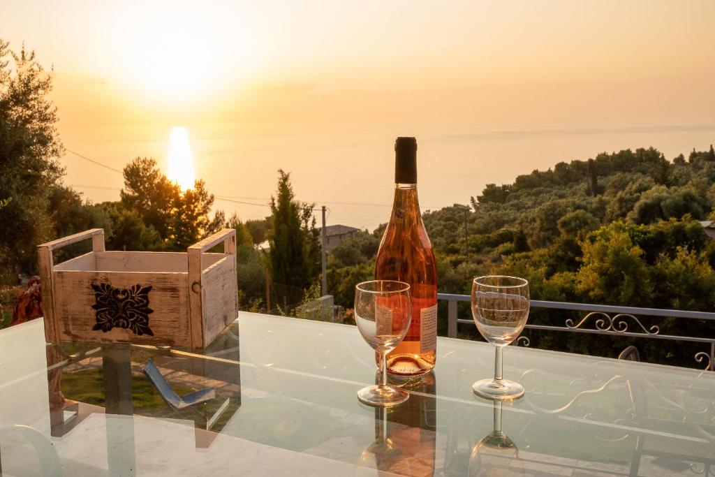 uma garrafa de vinho e dois copos numa mesa em Sun And Stone em Athani