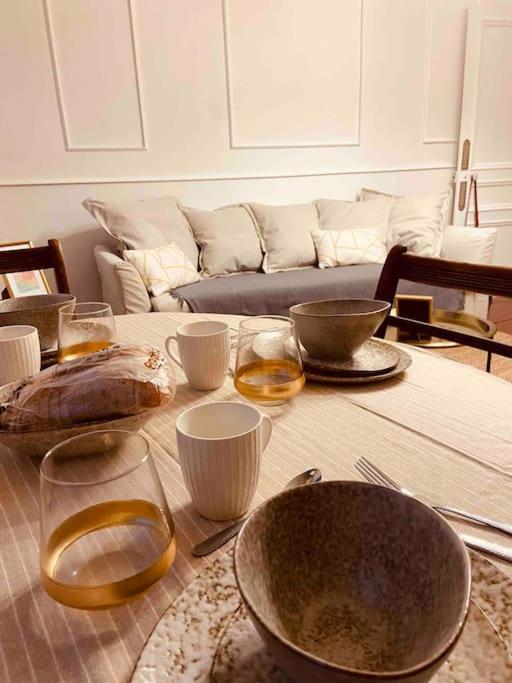 une table avec des bols, des verres et un canapé dans l'établissement Petit cocon rien que pour vous !, à Dieppe