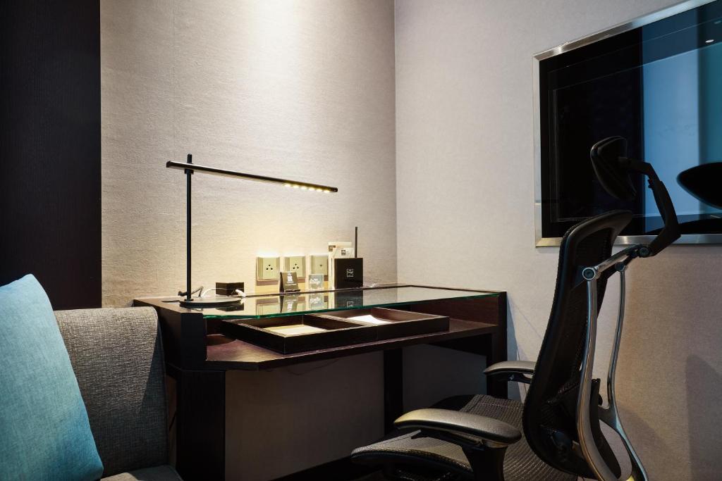 a glass desk with a chair in a hotel room at The Tango Hotel Taipei Nanshi in Taipei