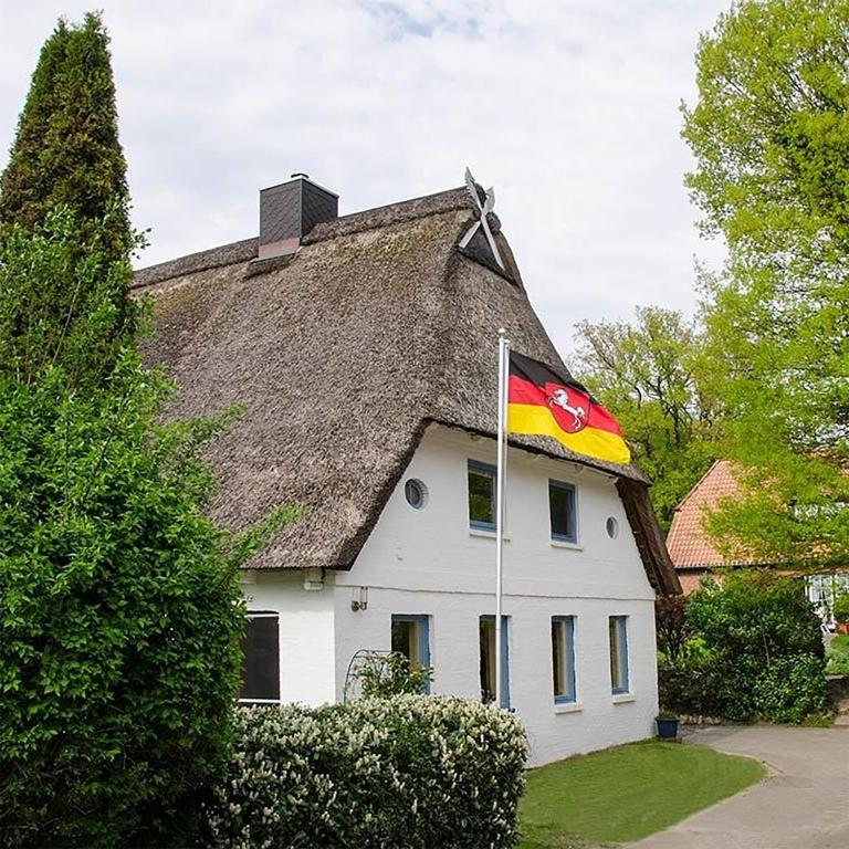a flag flying in front of a house with a roof at Ferienwohnung am Sandbarg in Jesteburg