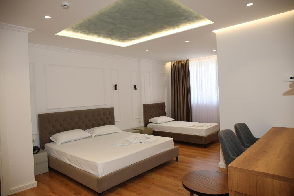 a bedroom with a bed and a couch and a table at Pashkaj Hotel in Pogradec