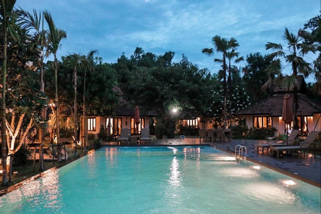 a swimming pool in a resort at night at Le Baan Thai Boutique Villa in Chiang Mai