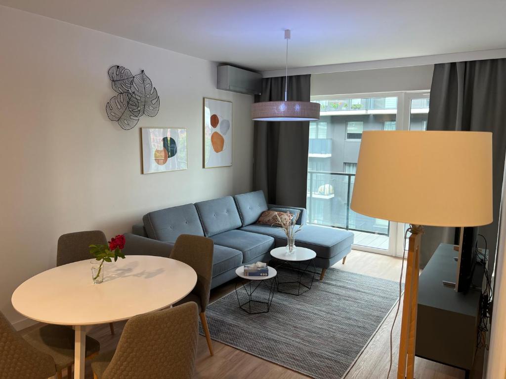 ein Wohnzimmer mit einem blauen Sofa und einem Tisch in der Unterkunft Apartament Mieszczański Klima-ParkigFree2x-Netflix-YouTube in Breslau