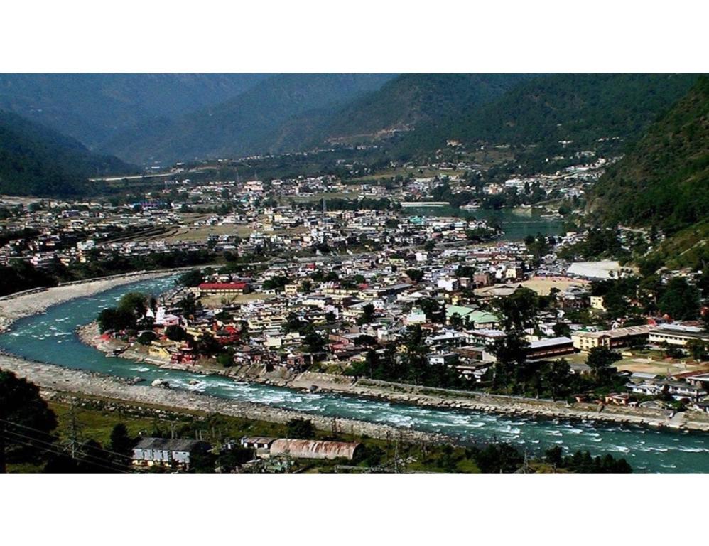 a view of a town with a river and a city at Hotel Aastha, Uttarkashi in Uttarkāshi