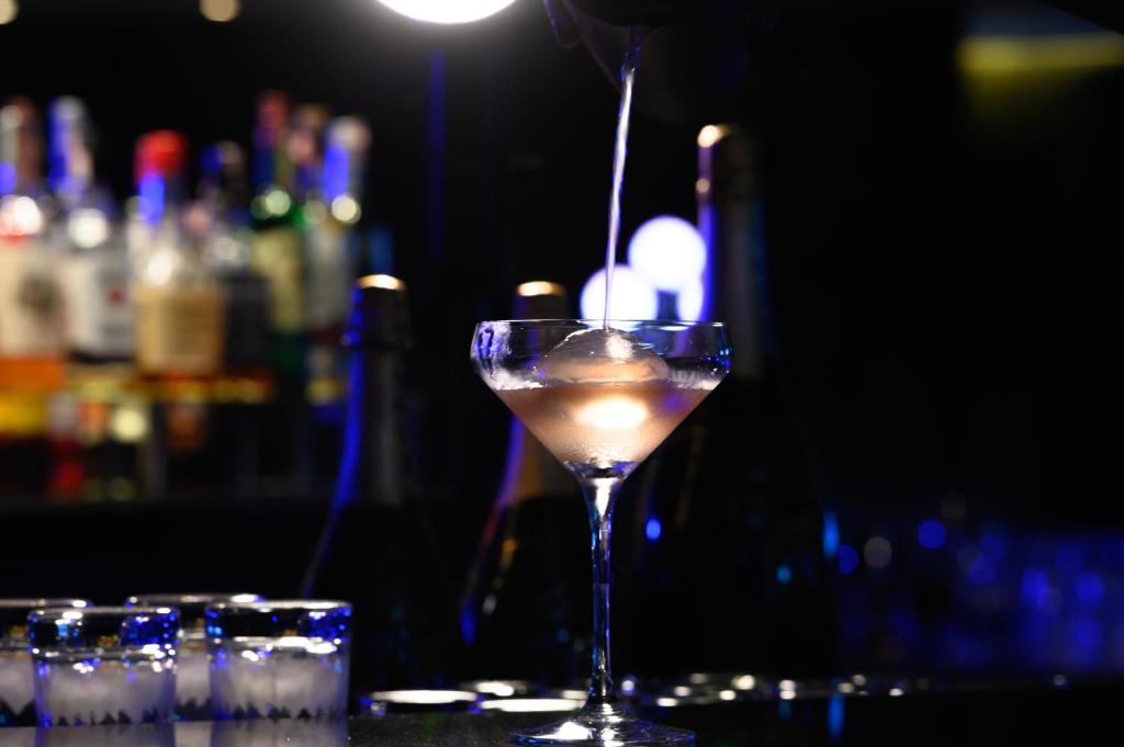 a drink in a martini glass sitting on a bar at Sheraton Grande Sukhumvit, a Luxury Collection Hotel, Bangkok in Bangkok