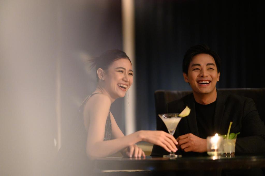 a man and a woman sitting at a table with a drink at Sheraton Grande Sukhumvit, a Luxury Collection Hotel, Bangkok in Bangkok