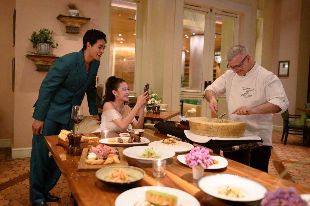 a group of people standing around a table with food at Sheraton Grande Sukhumvit, a Luxury Collection Hotel, Bangkok in Bangkok