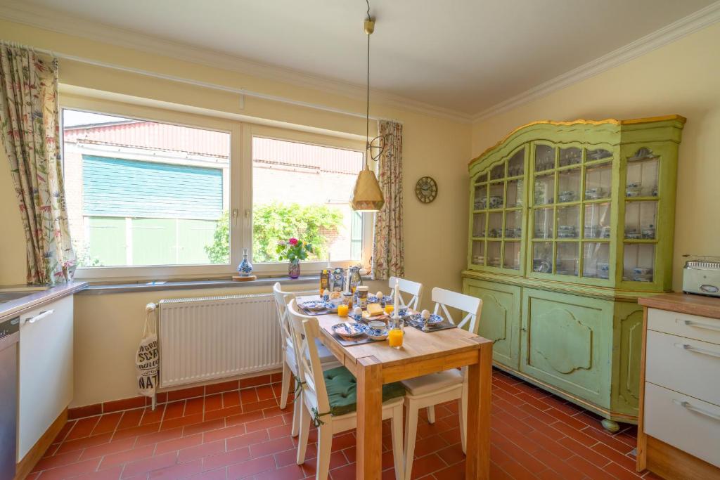 a kitchen with a table with chairs and a green cabinet at Maisonette Parforce in Gorleben