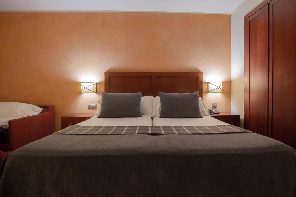 A bed or beds in a room at Hotel Màgic Andorra