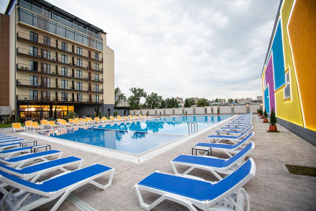 a swimming pool with lounge chairs next to a building at West Inn Georgia in Kutaisi