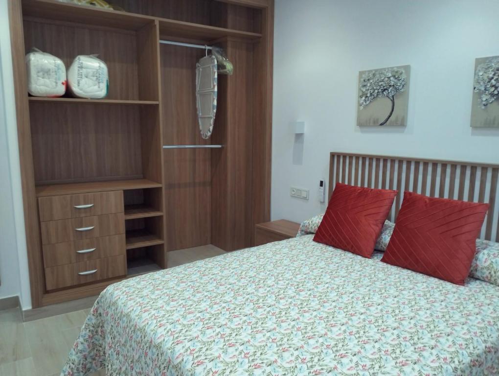 um quarto com uma cama com almofadas vermelhas em Casa Margarita Confort em Ardales