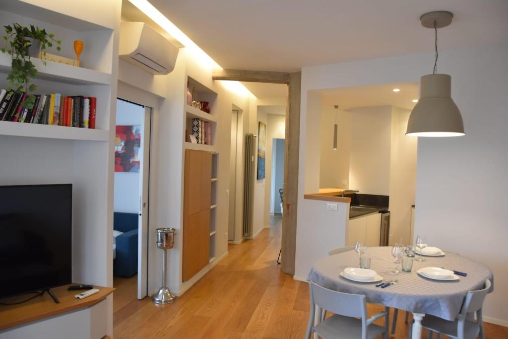 een eetkamer met een witte tafel en een televisie bij Appartamento di design con terrazza privata in Rome