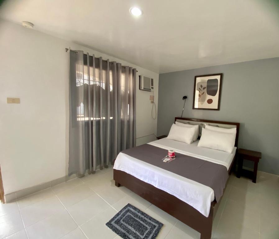 sypialnia z dużym łóżkiem i oknem w obiekcie Marion Roos Hotel w mieście Puerto Galera