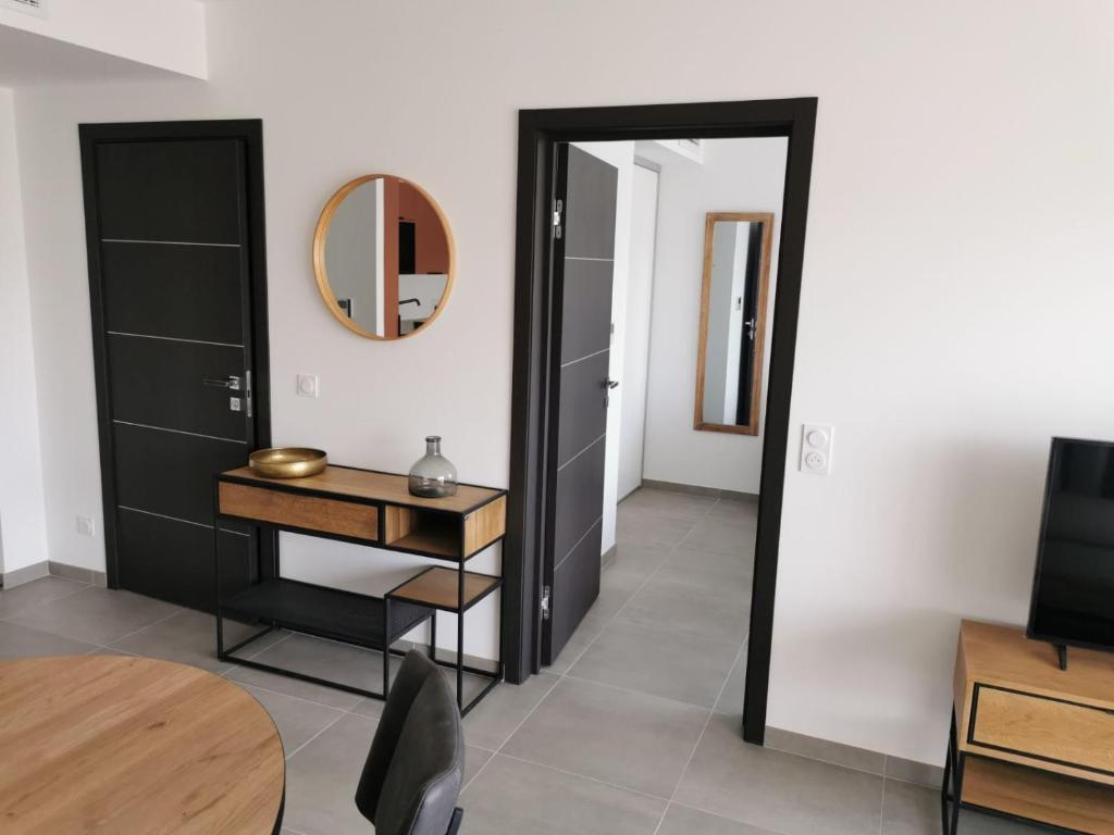 a room with a mirror and a desk and a table at Domaine d'Arca Flaubert 20 T2 4 pers in Porto-Vecchio
