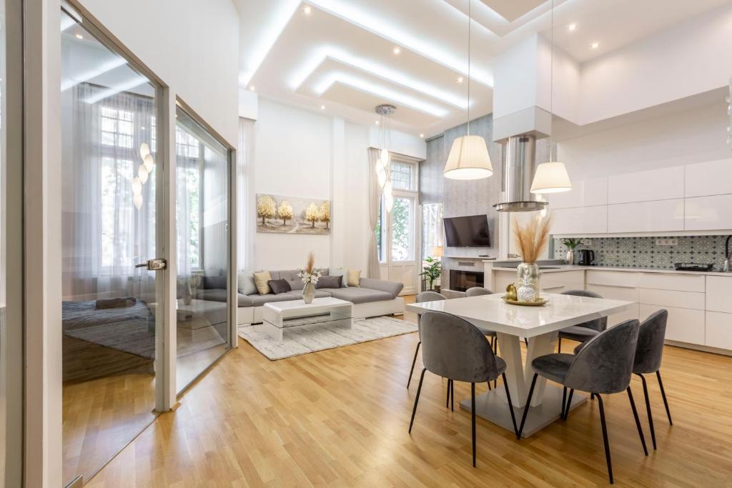 a kitchen and living room with a table and chairs at Luxurious & Spacious Downtown Residence in Liszt Ferenc Square in Budapest