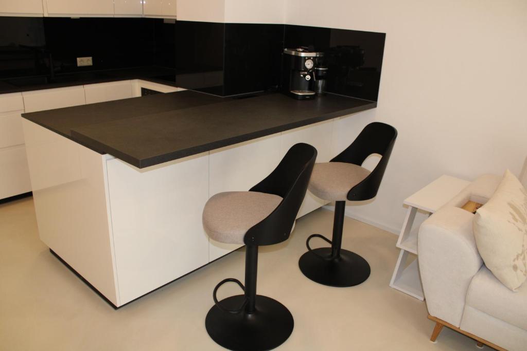 eine Küche mit zwei Hockern und einer Arbeitsplatte in der Unterkunft Wohnung am Traunsee in Gmunden