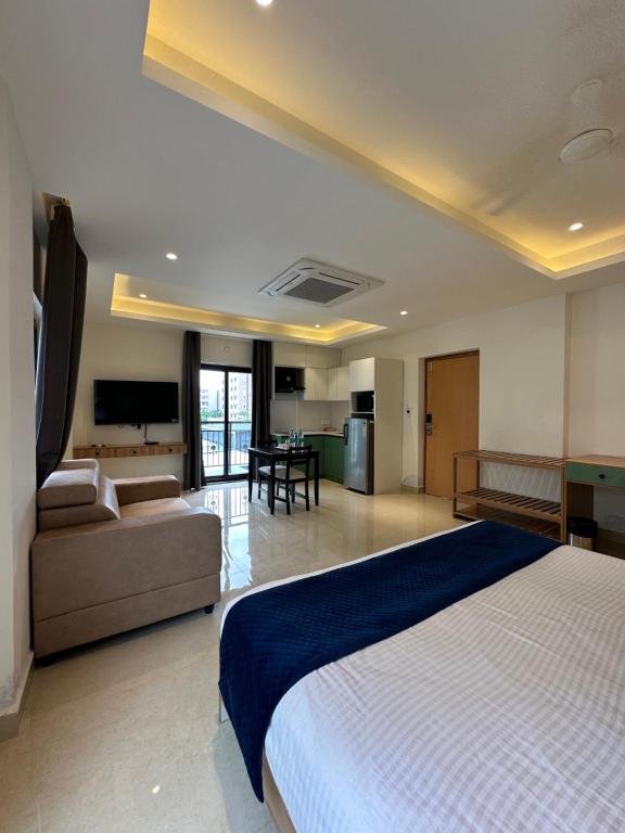 a bedroom with a bed and a couch and a table at Western Suites HiTech City in Hyderabad