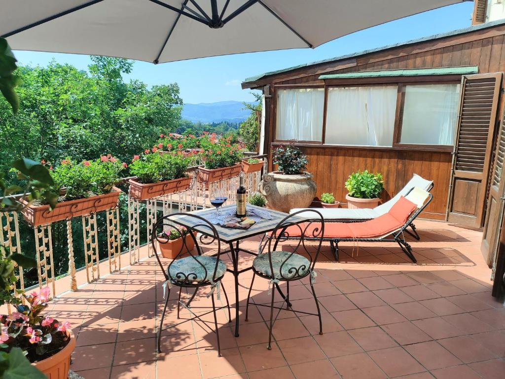 un patio con mesa, sillas y flores en Casa Vacanza in Casentino, en Bibbiena