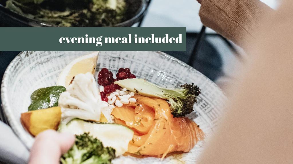 a person holding a glass bowl filled with food at Clarion Collection Hotel Bastion in Oslo