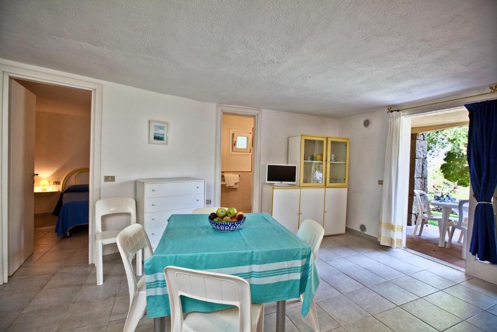 Una cocina y un comedor con mesa y sillas. en ISA-Residence with swimming-pool in Porto Rotondo at only 500 m from the beach, en Porto Rotondo