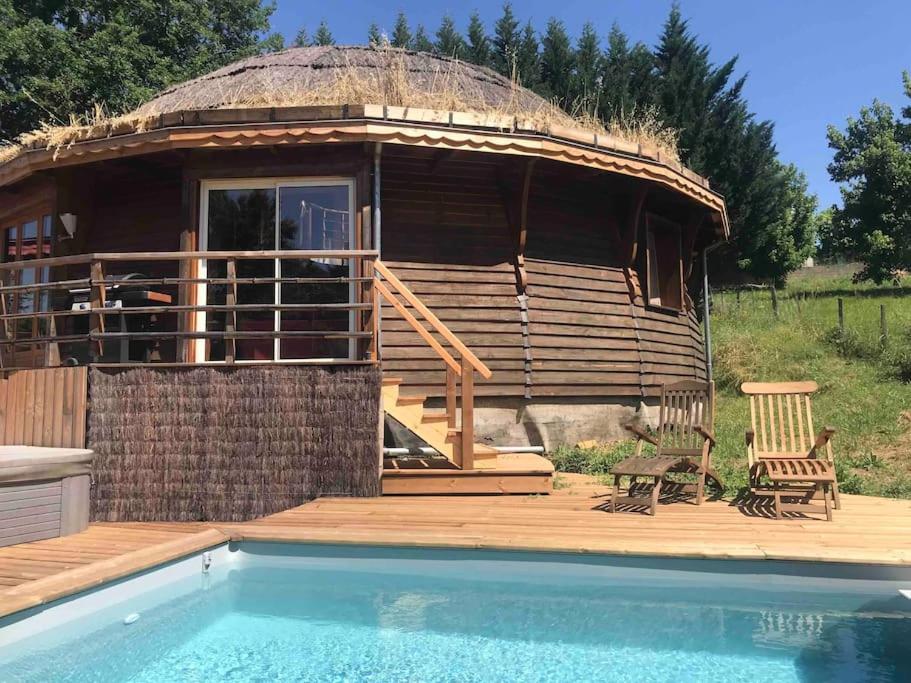 una cabaña grande con piscina frente a ella en Maison ronde atypique en bois, en Carmaux