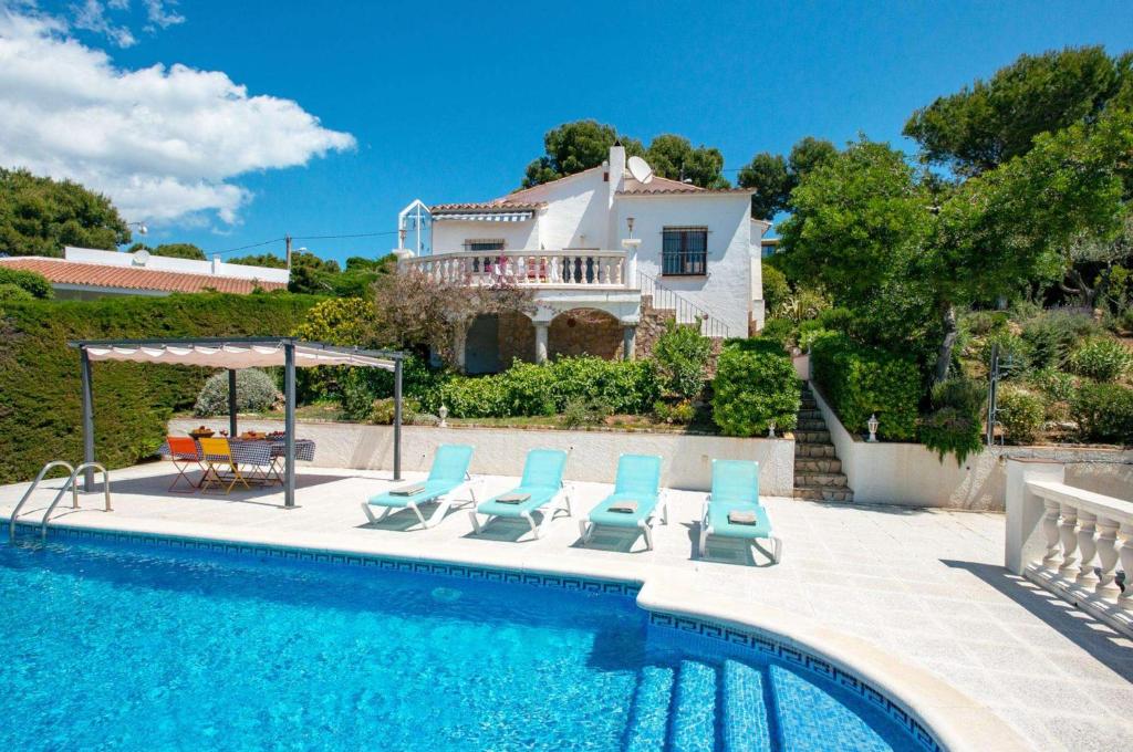 una piscina con sillas y una casa en el fondo en Villa Sophia, en Tamariu