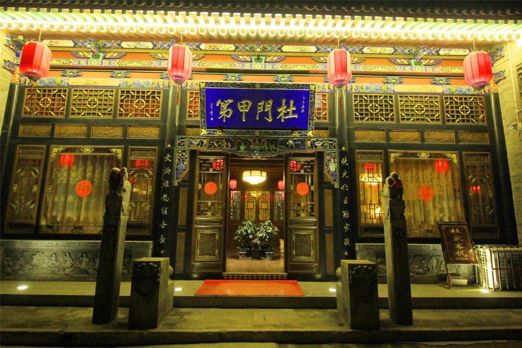 un bâtiment avec une porte munie d'un panneau. dans l'établissement Pingyao hu lu wa Home Inn, à Pingyao
