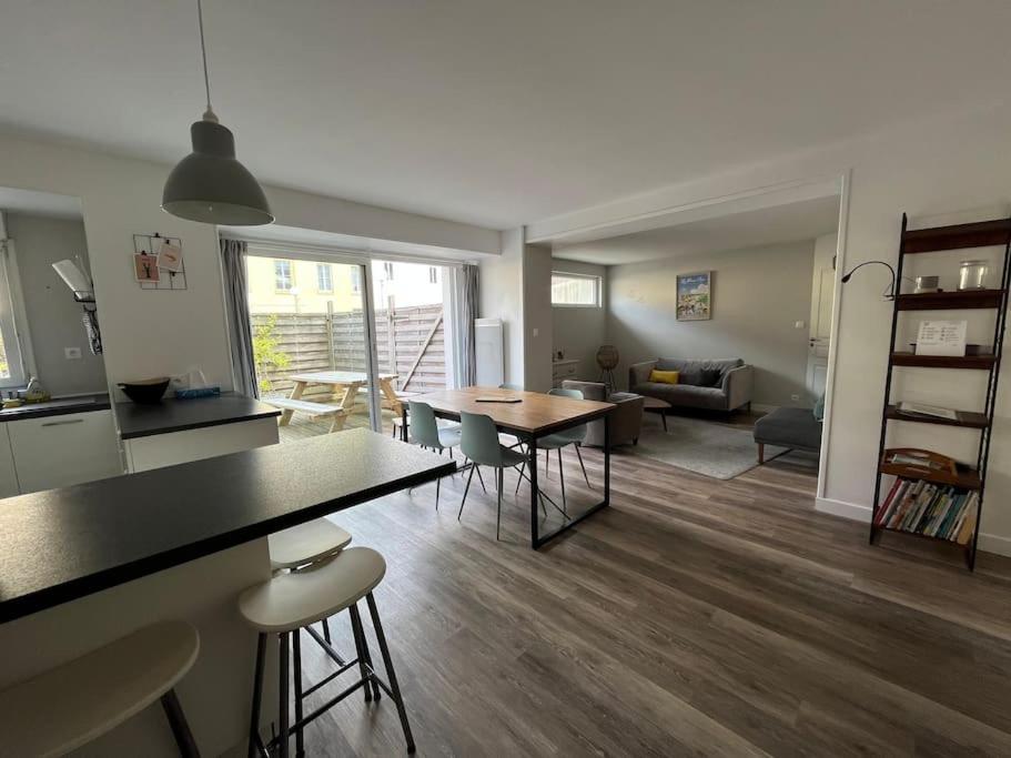 a kitchen and living room with a table and chairs at La bonne pioche - centre et plage in Wimereux