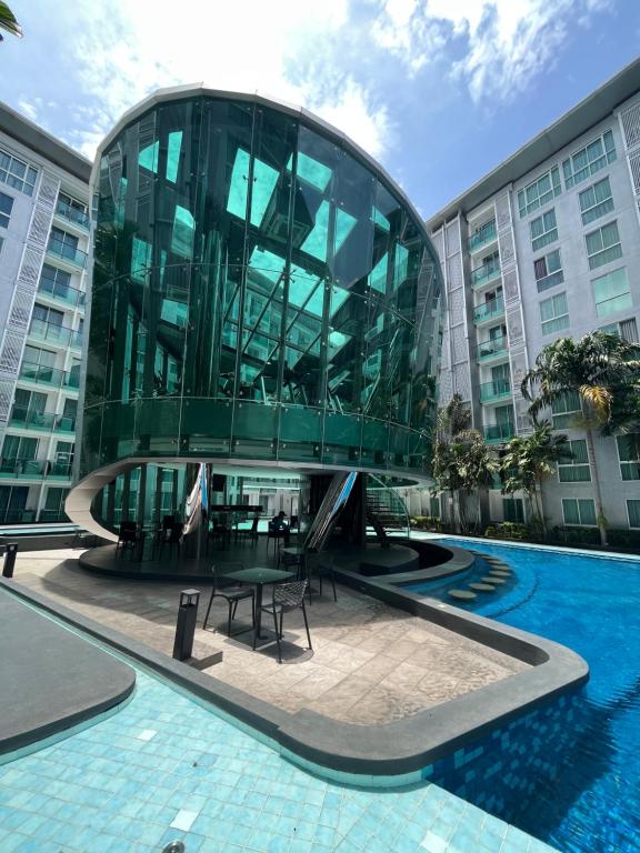 a glass building with a table in front of a pool at City center residents Pool view in Pattaya Central