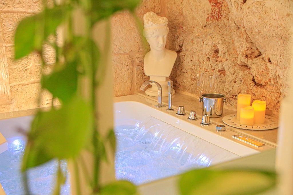 un bagno con lavandino, statua e candele di GB Grotta Bianca a Ostuni