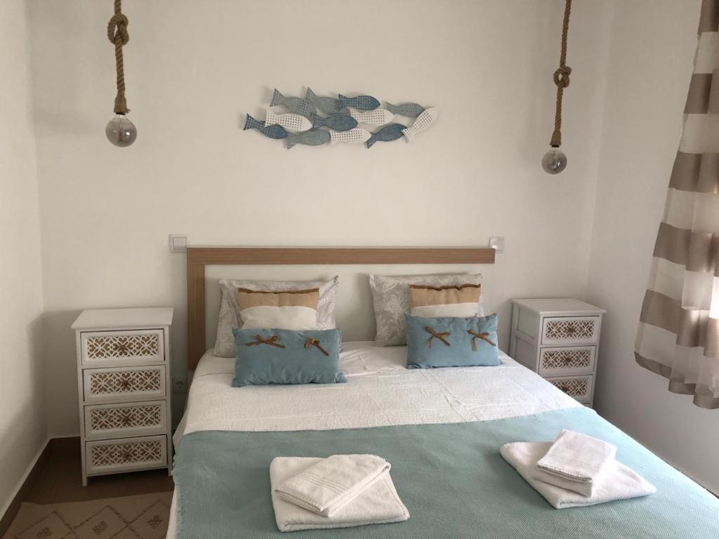 una camera con un letto con due cuscini sopra di Casa dos Pexins Buzina Sitio a Nazaré