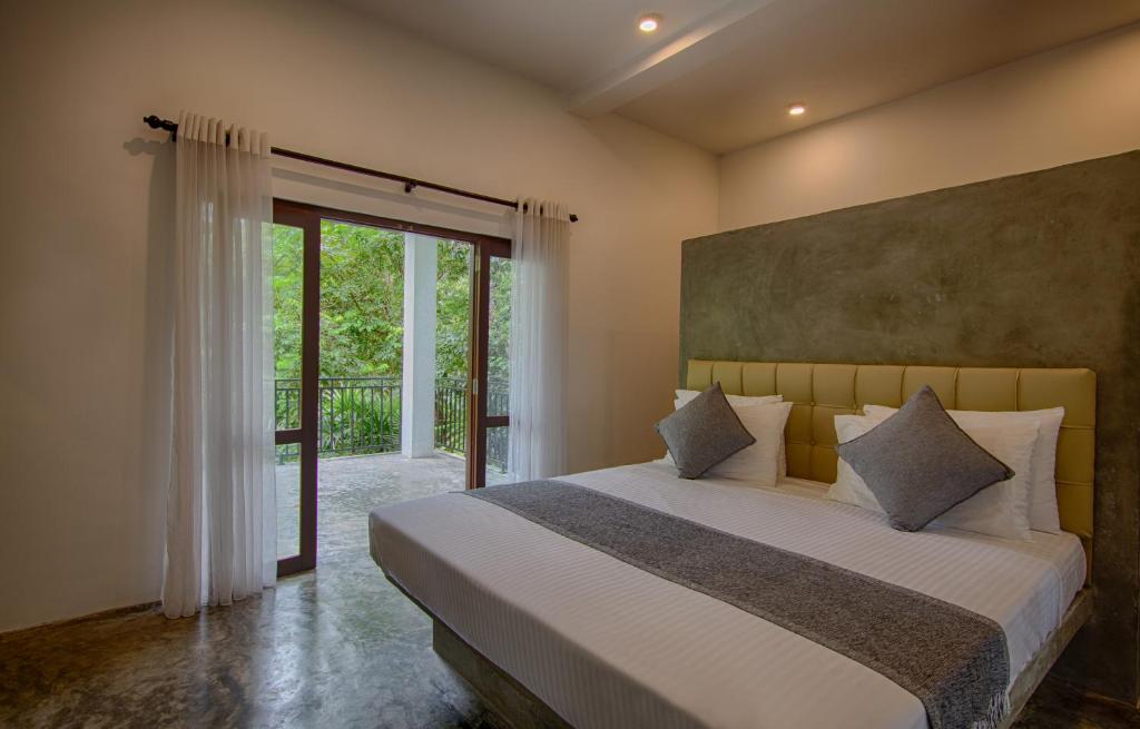 a bedroom with a large bed and a sliding glass door at Wild Nest Villa Unawatuna in Unawatuna