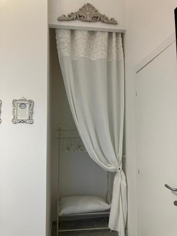a white curtain in a room with a window at Althea in Viareggio