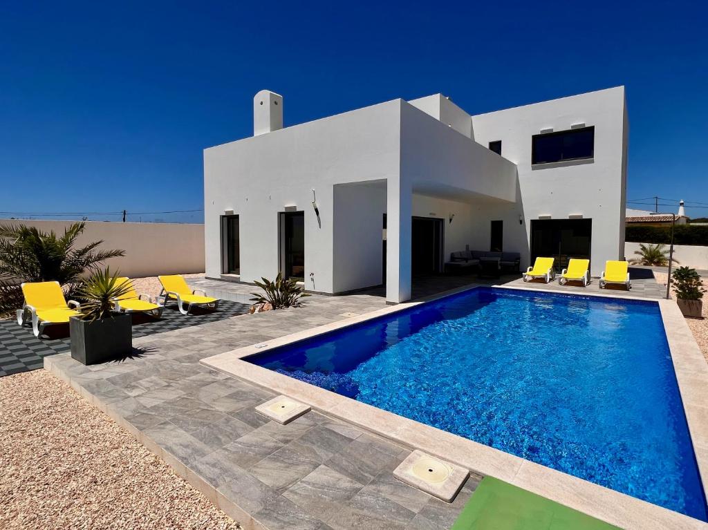 a villa with a swimming pool in front of a house at Villa Sonata in Ingrina Sol in Raposeira