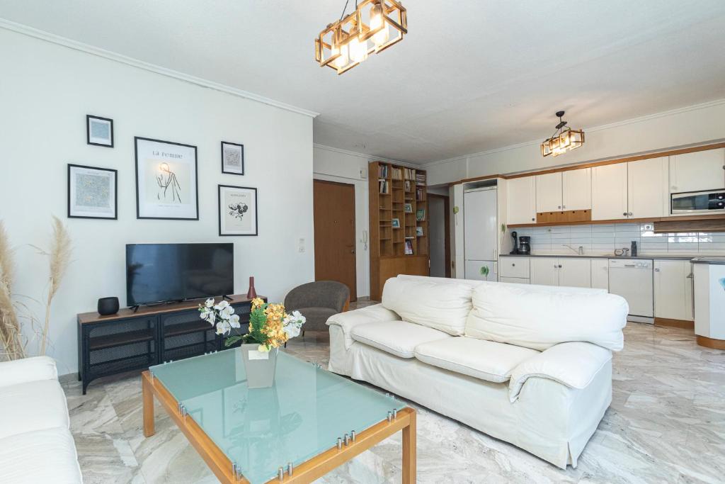 sala de estar con sofá blanco y mesa en Houseloft Kalamaria Highview, en Tesalónica