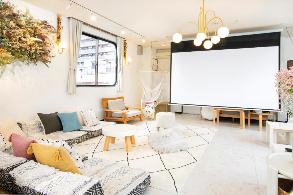 a living room with couches and a projection screen at Meee Asakusa3F4F 浅草徒歩3分 140平米Max22名 無料駐車場 屋上絶景 渋谷直通 in Tokyo