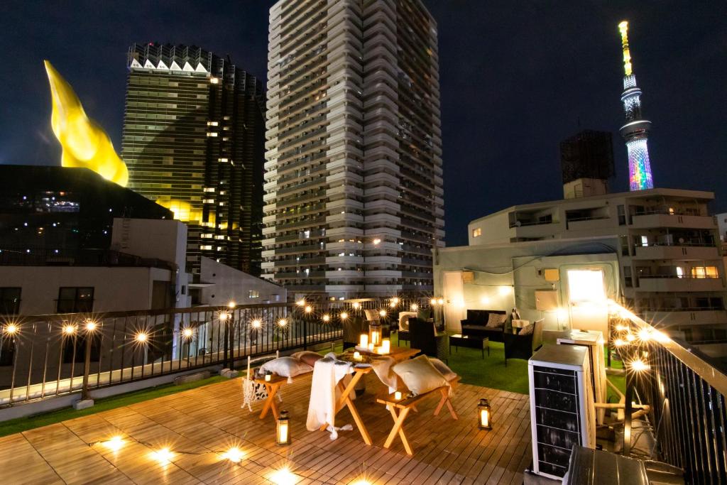 a rooftop deck with a view of a city at night at Meee Asakusa3F4F 浅草徒歩3分 140平米Max22名 無料駐車場 屋上絶景 渋谷直通 in Tokyo