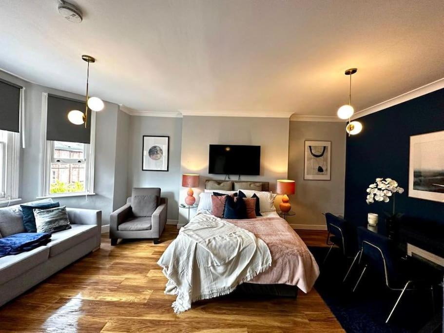 a bedroom with a bed and a couch and a tv at Stylish studio near Regent’s Park n7 in London