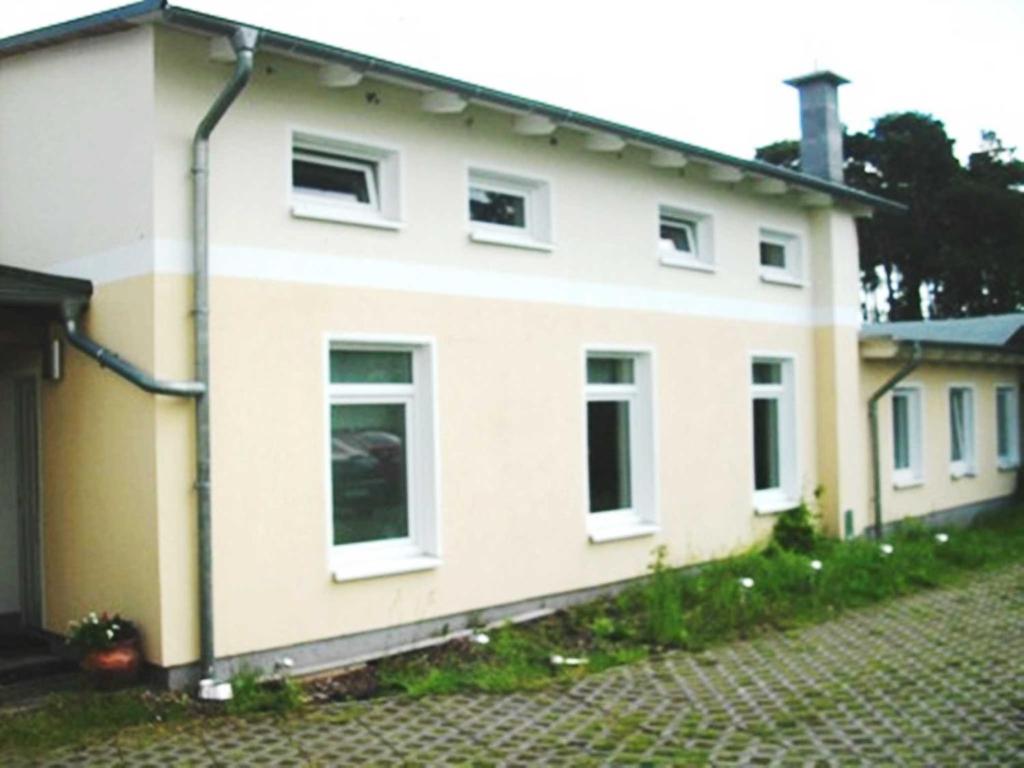 Casa blanca con ventanas blancas y entrada en Ferienhaus DH-38879, en Lubmin
