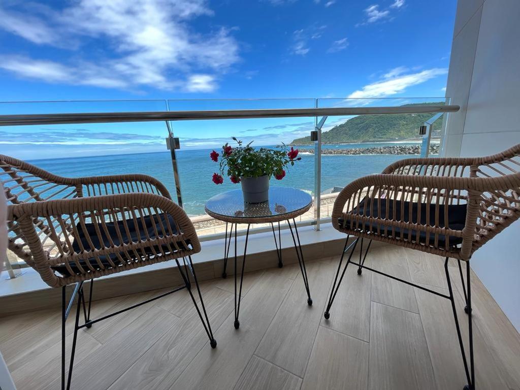 un balcón con 2 sillas y una mesa con flores en Pensión Itxasoa, en San Sebastián