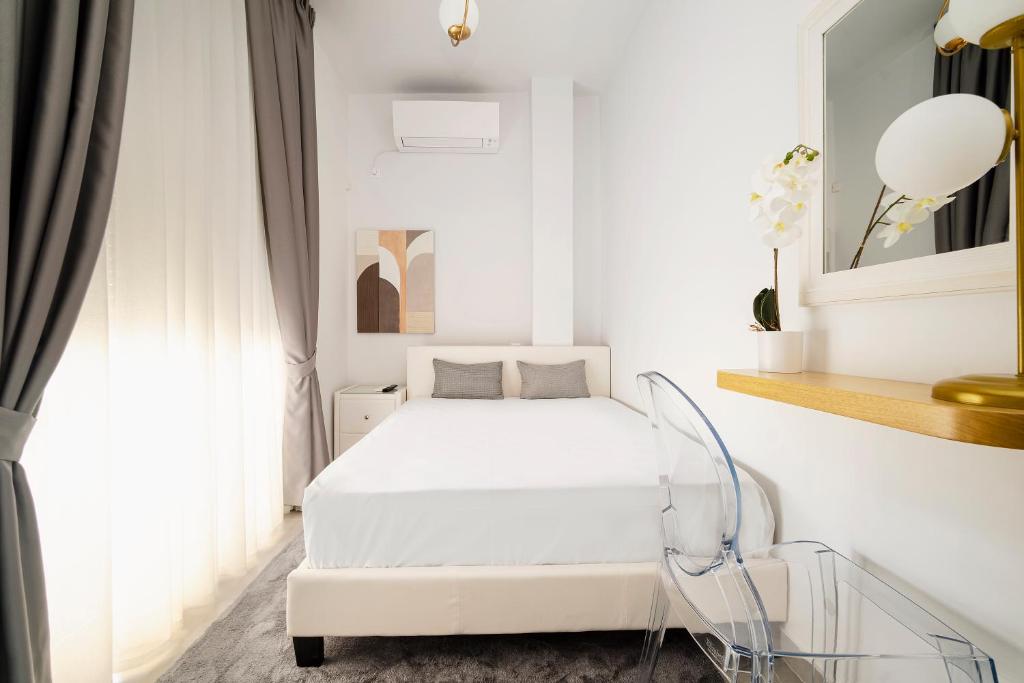 um quarto branco com uma cama branca e uma janela em GK Plato Academy em Atenas
